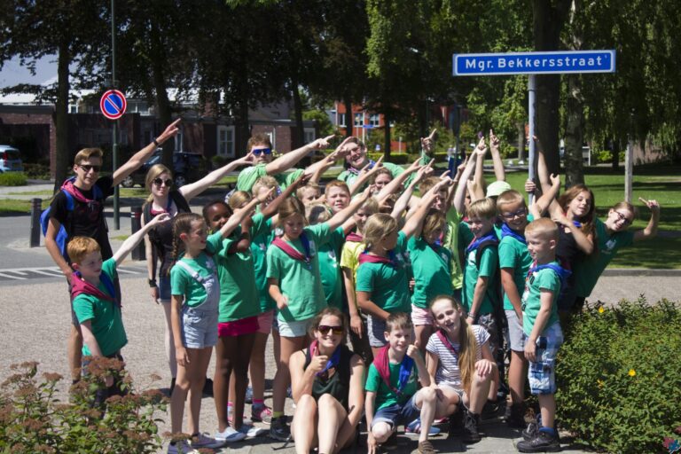 Welpen bij het straatnaambord van de Mgr. Bekkersstraat